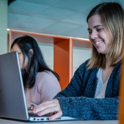 A person smiling and using a laptop