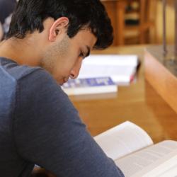 A student reads a book in a library