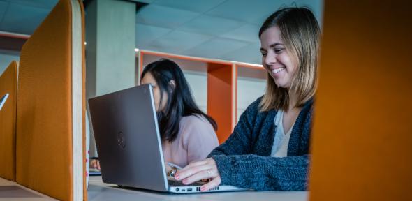 A person smiling and using a laptop