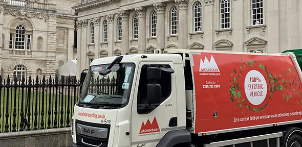 Recyling van in front of white buildings
