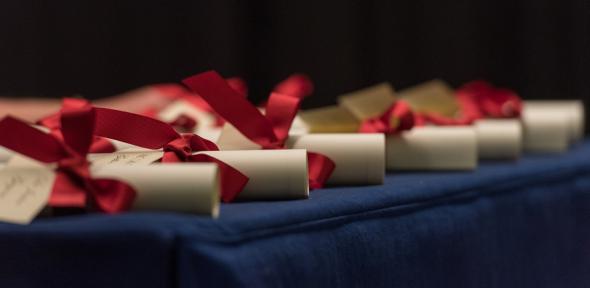 A number of academic scrolls tied with red ribbon